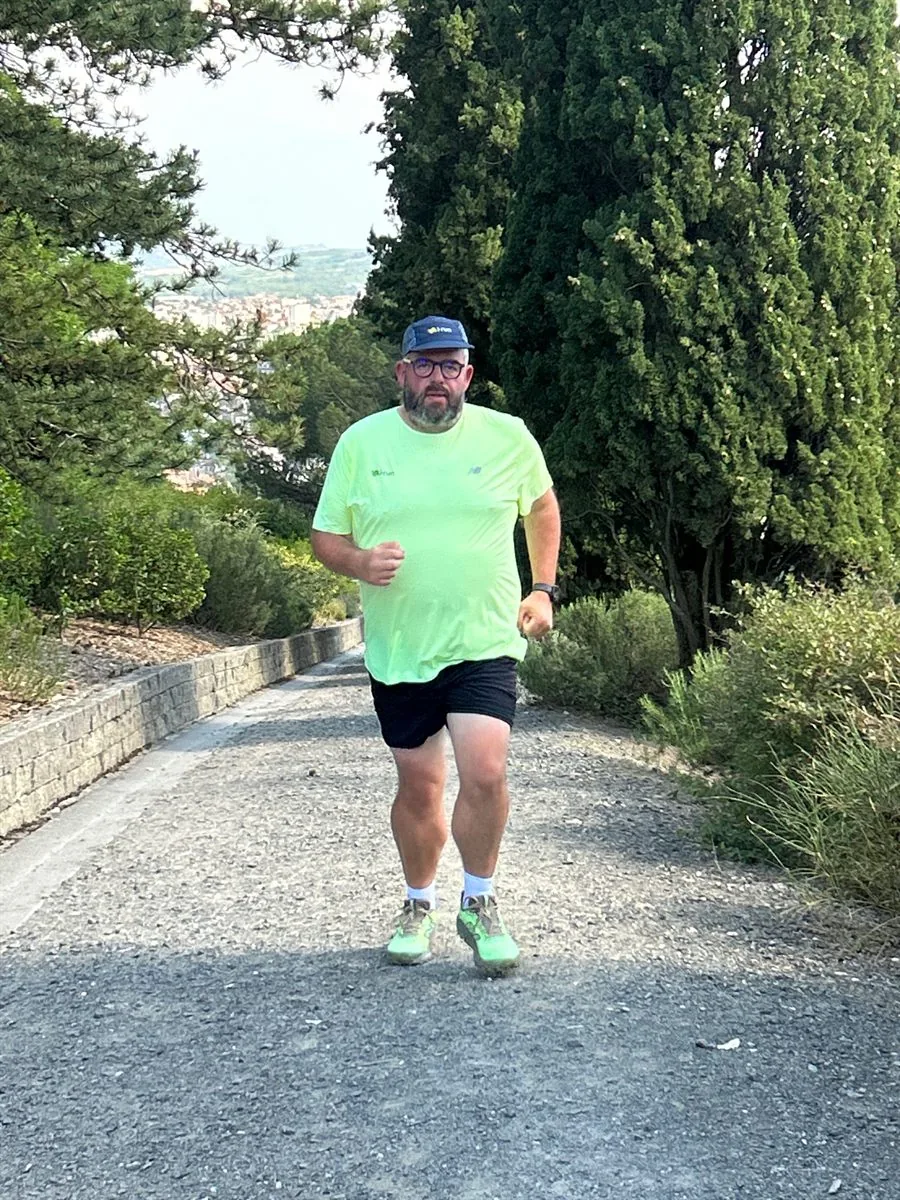 Cédric Debacq à l'entraînement, en course sur une route bordée d'arbres