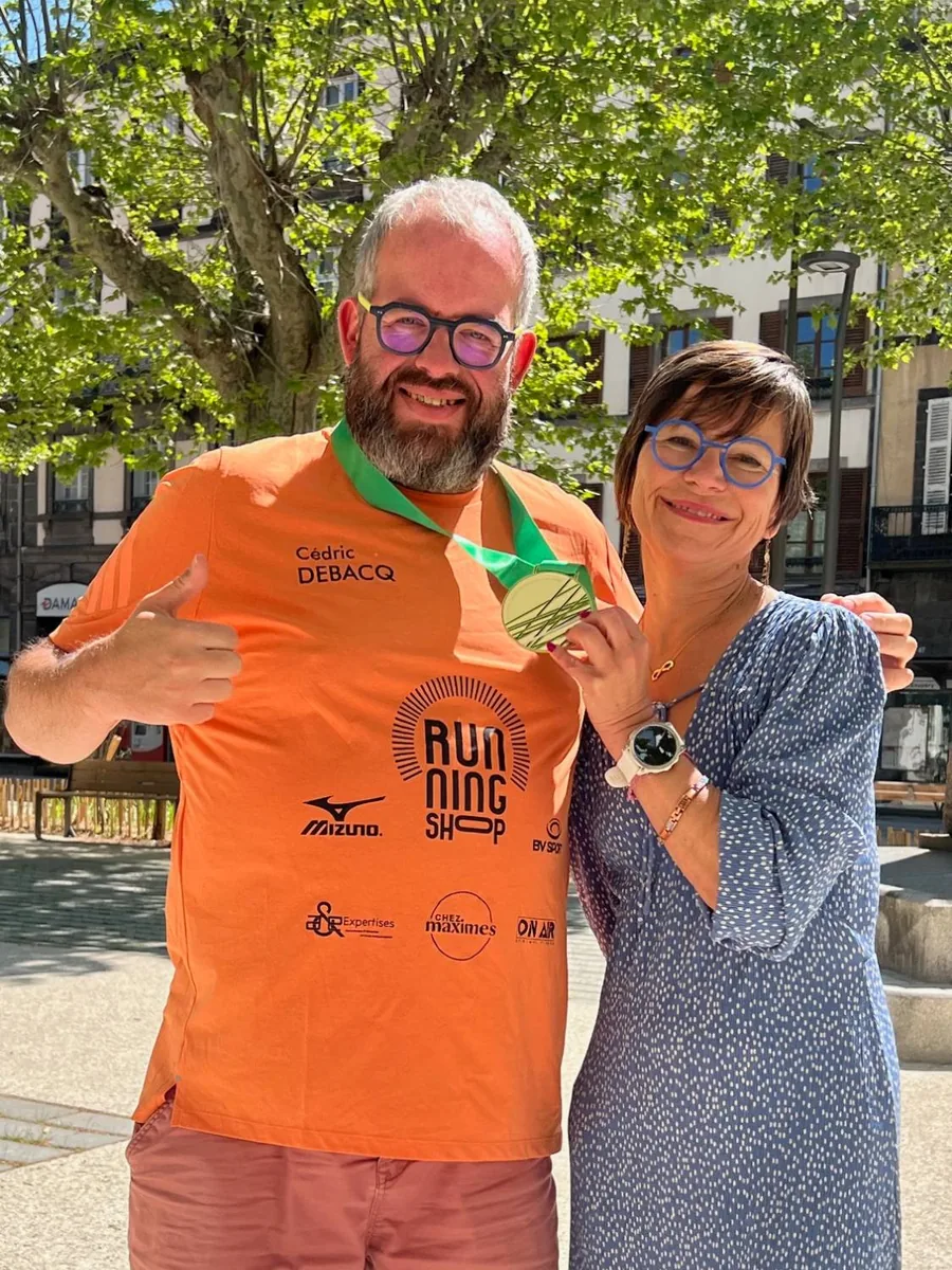 Cédric Debacq et Fabienne Mineau, médaille de finisher autour du cou, en tee-shirt Running Shop floqué des logos de ses partenaires, à Clermont-Ferrand